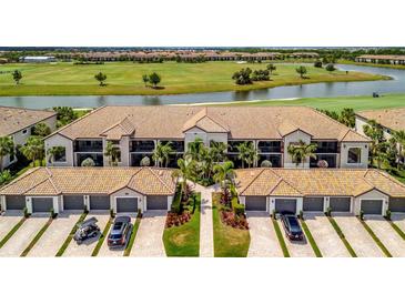 Stunning aerial view of the property with a beautiful golf course and lake in the backdrop at 5694 Palmer Cir # 202, Bradenton, FL 34211