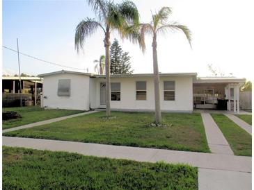 Charming single-story home with a well-maintained lawn and mature palm trees in the front yard at 6339 Pontiac Ln, North Port, FL 34287