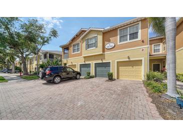 Inviting townhome with brick driveway, attached garage, and lush landscaping at 7983 Limestone Ln # 14-201, Sarasota, FL 34233