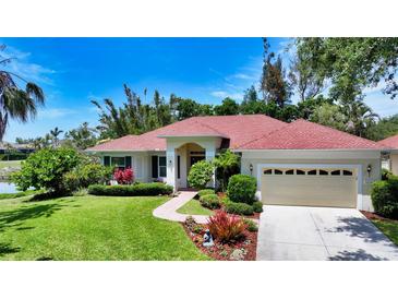 Well-maintained single Gathering home features lush landscaping, mature trees, and a brick walkway at 9238 13Th Avenue Nw Cir, Bradenton, FL 34209