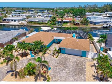 Stunning waterfront home with lush landscaping, a paver driveway, and a serene canal view at 10016 Spoonbill E Rd, Bradenton, FL 34209