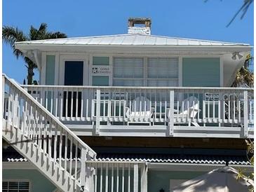 Inviting two-story beach house featuring a cozy balcony with relaxing chairs and ample natural light at 104 29Th St # 3, Holmes Beach, FL 34217