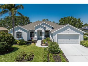 Charming single-story home with a well-manicured lawn, two-car garage, and light-blue exterior at 12005 Summer Meadow Dr, Lakewood Ranch, FL 34202