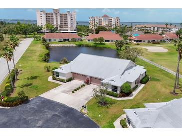 Stunning aerial view of home with pond, golf course, and nearby waterfront condos, offering serene Florida living at 1714 Fairway Trce, Palmetto, FL 34221