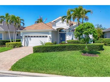 Beautiful single-story home boasts a manicured lawn, lush landscaping, and a two-car garage with a brick paver driveway at 1806 85Th Nw Ct, Bradenton, FL 34209
