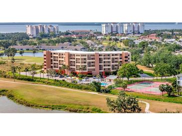 Beautiful condominium building with a pool and tennis court in a lush, green community at 2311 14Th W Ave # 208, Palmetto, FL 34221