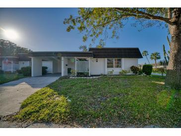 Charming single-story home with a lush green lawn and a convenient carport at 3904 Ashwood Ln, Sarasota, FL 34232