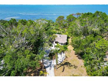 Stunning aerial view of lush landscaping surrounding waterfront home with a serene water view at 7620 Westmoreland Dr, Sarasota, FL 34243