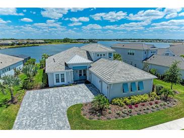 Stunning waterfront home boasts lush landscaping, a paved driveway, and a three-car garage at 8059 Waterbend Trl, Sarasota, FL 34240