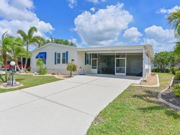 Well-maintained single Gathering home with a covered porch, tidy landscaping, and large driveway under sunny skies at 8404 Imperial Cir # 8404, Palmetto, FL 34221