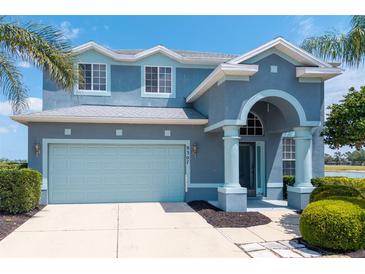 Two-story home boasts beautiful blue paint, manicured landscaping, and a large garage at 9307 Raes Creek Pl, Palmetto, FL 34221