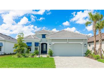 Beautifully landscaped single Gathering home featuring a well manicured lawn and a charming two car garage at 15722 San Lazzaro Ave, Lakewood Ranch, FL 34211