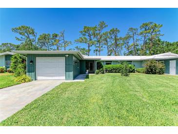 Charming single-story home with a well-maintained lawn, attached garage, and colorful green siding at 1622 Stafford Ln # 1205, Sarasota, FL 34232