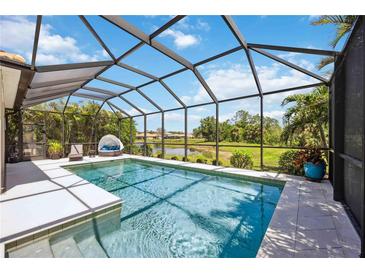 Enclosed pool area featuring a lounge area and view of the lush greenery and water at 2177 Weaver Bird Ln, Venice, FL 34292