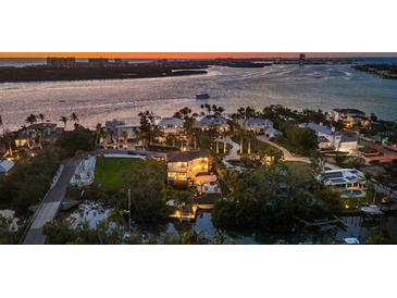 Scenic aerial view of a waterfront neighborhood with boats on the water and stunning sunset at 3465 Gulfmead Dr, Sarasota, FL 34242