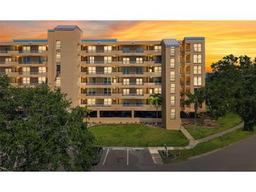 A beautiful condo complex with balconies and palm trees set against a vibrant sunset sky at 4410 Fairways Blvd # 605, Bradenton, FL 34209