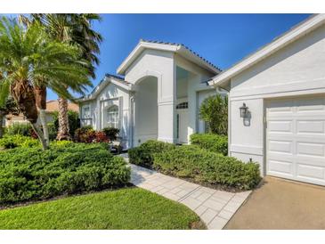 Inviting home featuring manicured landscaping and a charming, tiled front walkway at 8718 Grey Oaks Ave, Sarasota, FL 34238