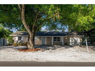 Charming single-story home with a gravel front yard and mature shade trees enhancing curb appeal at 95 S Briggs Ave, Sarasota, FL 34237