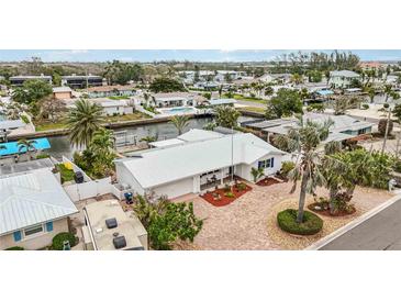 Beautiful waterfront home with a metal roof and a paved driveway in a coastal community at 10308 Kingfisher W Rd, Bradenton, FL 34209