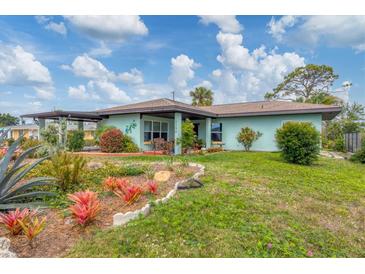Quaint single-story home with a well-manicured front lawn, garden, and inviting curb appeal at 1156 Lemon Bay Dr, Venice, FL 34293