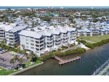 Beautiful waterfront condo featuring lush landscaping, a private dock, and coastal views at 1280 Dolphin Bay Way # 503, Sarasota, FL 34242
