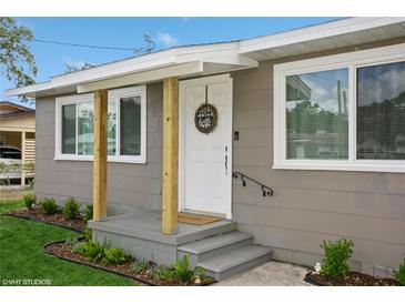 Charming home featuring a cozy front porch with natural wood supports and gray painted steps at 1813 5Th W St, Palmetto, FL 34221