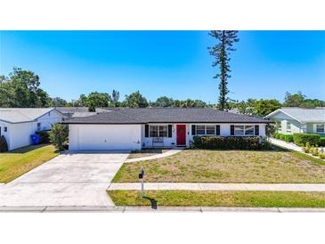 Charming single-story home featuring a red front door, well-manicured lawn, and an attached one car garage at 2705 21St W Ave, Bradenton, FL 34205