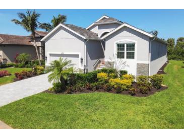 Charming single-Gathering home featuring a well-manicured lawn, and a driveway leading to the garage at 6228 Champions Row St, Bradenton, FL 34210