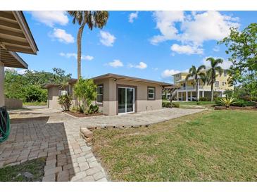 Charming backyard featuring a lovely patio, green grass, and beautiful landscaping that accents the home's exterior at 6718 68Th E Ave, Bradenton, FL 34203