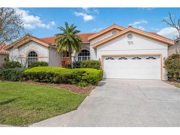 Charming single-story home with a well-manicured lawn, a two-car garage, and a red tile roof at 8824 Havenridge Dr, Sarasota, FL 34238