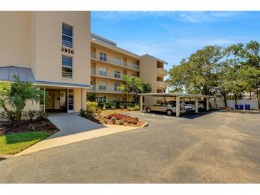 Condominium building with covered parking, landscaping and beige color scheme under sunny skies at 3950 Ironwood Cir # 206, Bradenton, FL 34209