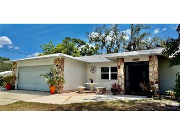 Charming single-story home featuring stone accents, a metal roof and a cozy front patio area at 1010 Gun Club Rd, Sarasota, FL 34232