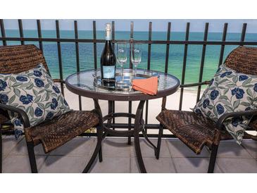 Table for two on balcony with wine and chairs overlooking a beautiful view of the ocean at 1212 Benjamin Franklin Dr # 901, Sarasota, FL 34236