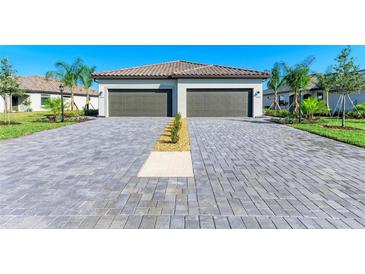 Beautiful two-car garage with paved driveway and meticulously landscaped front yard at 15503 Sunny Day Dr, Bradenton, FL 34211