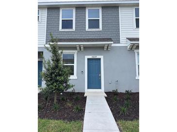 Charming two-story home with a blue front door and landscaped yard at 16622 San Nicola Pl, Bradenton, FL 34211