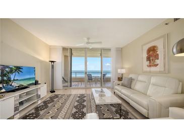 Bright living room with a modern rug, comfortable white seating, and a sliding glass door opening to a beautiful ocean view at 3080 Grand Bay Blvd # 533, Longboat Key, FL 34228