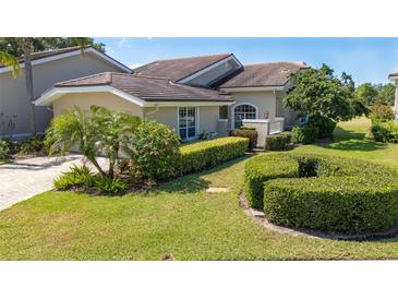 Beautiful single-story home featuring a well-manicured lawn, mature landscaping, and a side entry two car garage at 4044 Penshurst Park, Sarasota, FL 34235