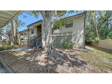 Two-story condo with a large tree, stairs leading to entrance, and neutral-colored facade at 5649 Summerside Ln # 41B, Sarasota, FL 34231