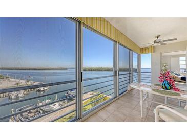 Enjoy waterfront views from this balcony with large sliding glass doors, boat dock views, and a cozy seating area at 600 Sutton Pl # B305, Longboat Key, FL 34228