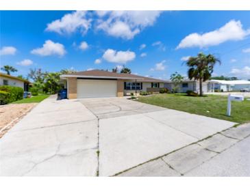 Charming single-story home featuring an attached two-car garage and a well-maintained lawn with palm trees at 609 Glen Oak Rd, Venice, FL 34293