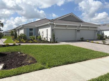 Charming single-story home featuring a well-manicured lawn and an attached two-car garage at 16152 Isola Pl, Bradenton, FL 34211