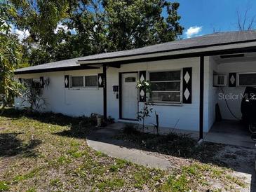 Charming single story home with white painted siding, black shutters, and mature trees at 2503 23Rd W Ave, Bradenton, FL 34205