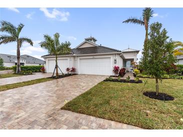 Beautiful single Gathering home featuring a brick driveway, two-car garage, and a well-manicured lawn at 256 Van Gogh Cv, Bradenton, FL 34212