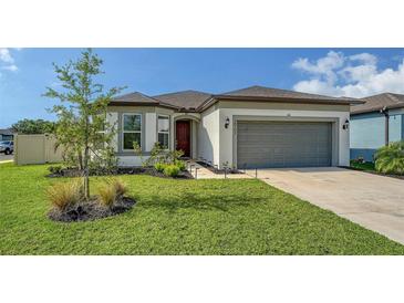 Beautiful single-Gathering home with a well-manicured lawn and a gray two-car garage door at 2907 61St E Ter, Ellenton, FL 34222