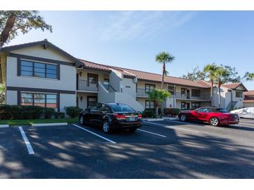 Inviting condo exterior with parking and mature landscaping for a serene residential appeal at 5630 Golf Pointe Dr # 206, Sarasota, FL 34243