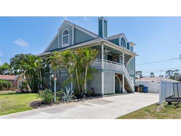 Inviting two-story home with a charming porch, lush landscaping, and a spacious driveway at 861 Nectar Rd, Venice, FL 34293