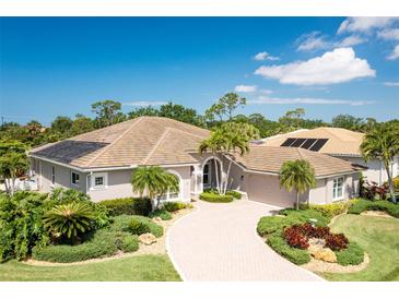 Stunning single-story home featuring a paver driveway, meticulously landscaped yard, and well-maintained tile roof at 8712 Grey Oaks Ave, Sarasota, FL 34238
