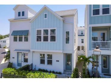 Charming two-story home featuring a blend of white and blue siding, complemented by lush greenery at 2340 Lindstrom St, Sarasota, FL 34237