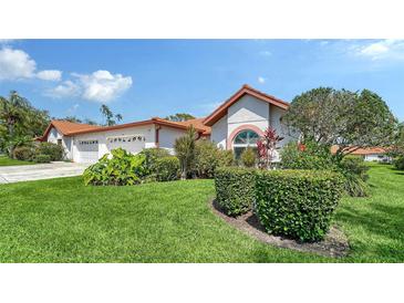Well-manicured front yard with vibrant green grass and colorful landscaping adds curb appeal to this home at 4131 Salernes Ave # 3051, Sarasota, FL 34233