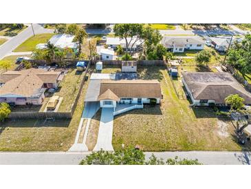 Aerial view of a single-Gathering home with a long driveway and mature trees in a residential neighborhood at 432 Crosby Ct, Sarasota, FL 34237